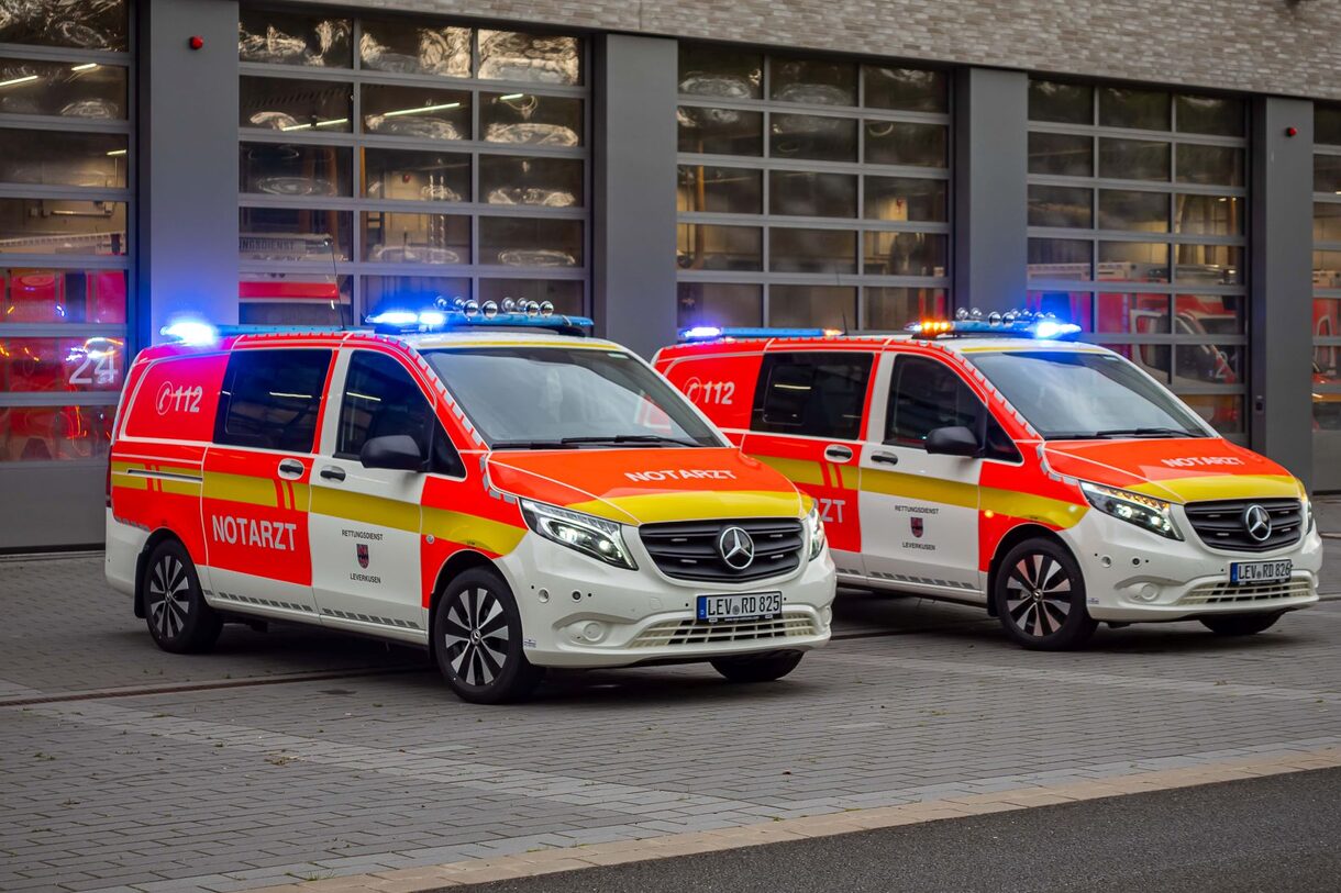 Ein Rettungsdienstmitarbeitender trägt einen Rucksack und Material zum Rettungswagen