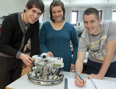 Drei Jugendliche bauen einen Roboter
