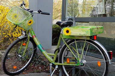 Grün gestrichenes Fahrrad mit Sonnenblumen