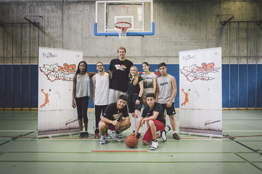 Dirk Nowitzki (Mitte) und Jugendliche in einer Sporthalle