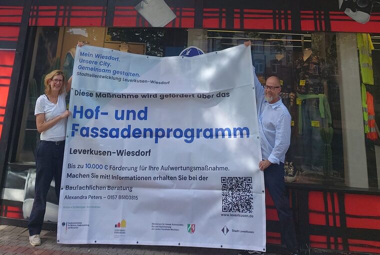 Silke de Roode vom Büro Stadt- und Regionalplanung Dr. Jansen und Geschäftsführer Guido Niggemann vor einer Fassade, die mit Mitteln aus dem Hof- und Fassadenprogramm umgestaltet wird