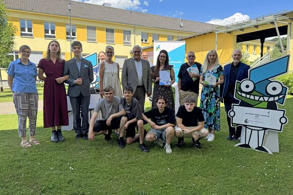Gruppenbild: Stadtdirektor Marc Adomat (Mitte) mit Schulleitung der "Schule an der Wupper" und einigen Schülerinnen und Schülern