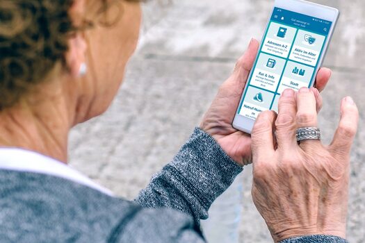 Ältere Frau nutzt die App auf ihrem Smartphone