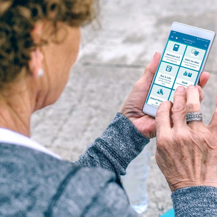 Ältere Frau nutzt die App auf ihrem Smartphone