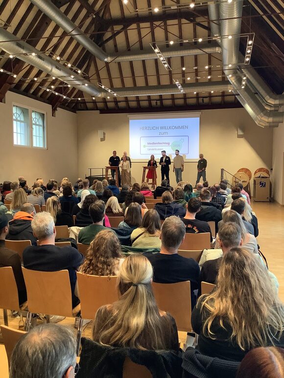 Mehrere Personen schauen sich einen Vortrag an