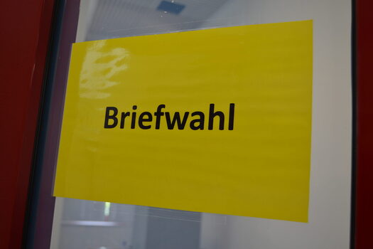 Gelbes Hinweisschild mit Schriftzug "Briefwahl"