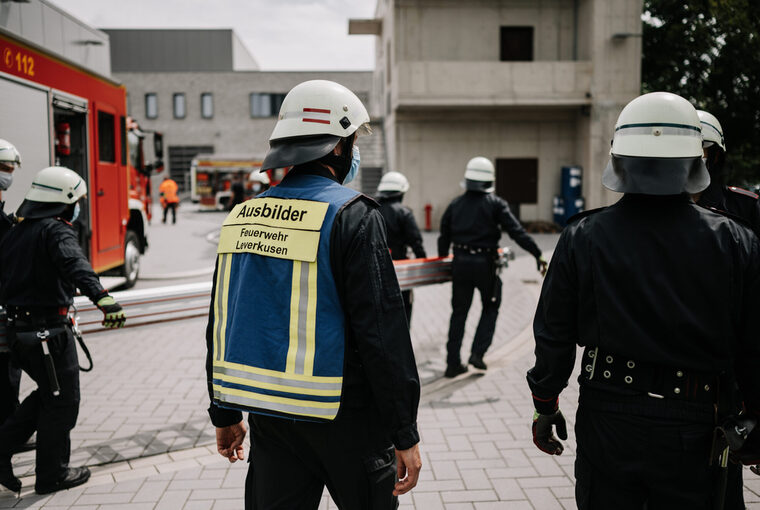 Feuerwehrmänner; einige tragen eine Leiter