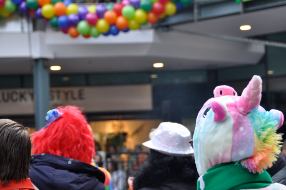 Verkleidete Personen stehen vor einer Ballongirlande