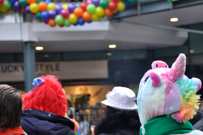 Verkleidete Personen stehen vor einer Ballongirlande