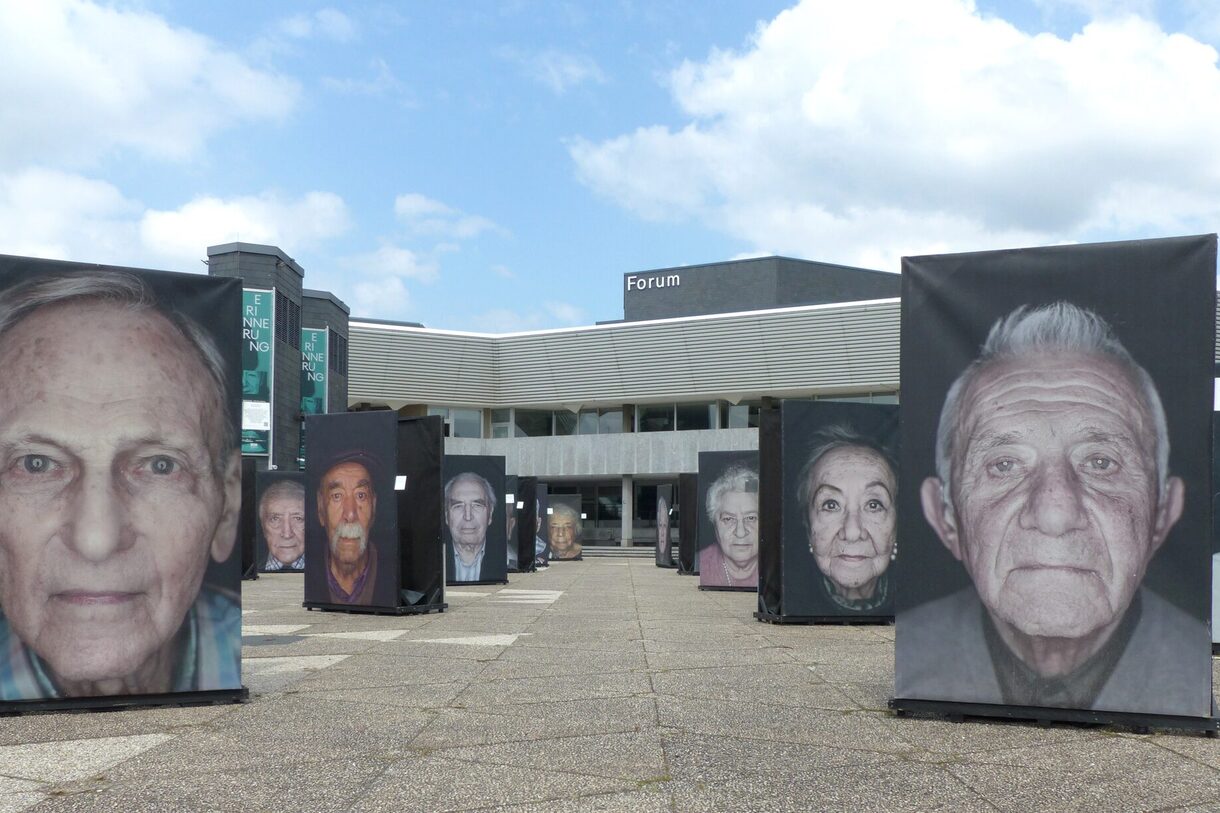 Die großformatigen Foto-Stelen auf dem Forum-Vorplatz zeigen Porträts von Überlebenden des Holocaust.